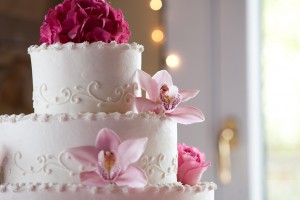Stax Bakery Wedding Cake 3 layer white with two different pink flowers and a group of magenta flowers on top.