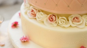 Stax Bakery Wedding cake with pink and white roses around the edge and a nice dotted design.